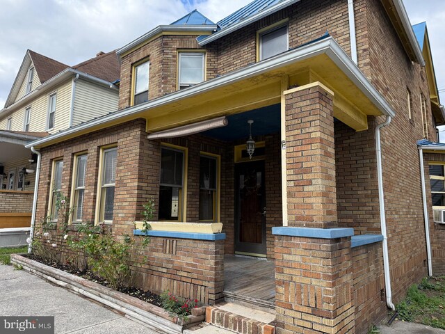 view of front of house with a porch and brick siding