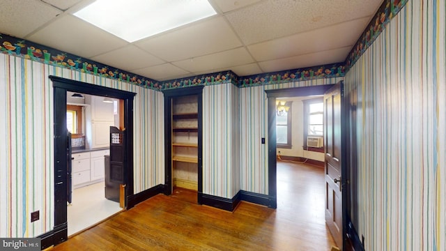 spare room with a paneled ceiling and hardwood / wood-style floors