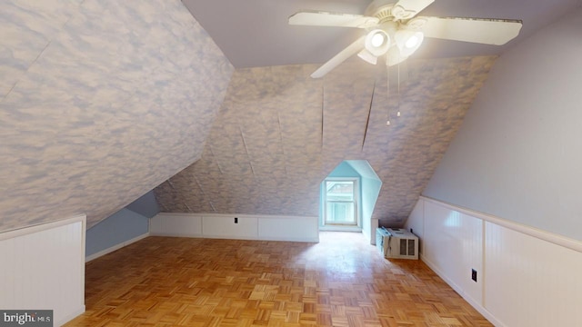 bonus room with ceiling fan, wainscoting, baseboards, and lofted ceiling