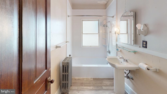 bathroom with shower / washtub combination, decorative backsplash, radiator heating unit, and wood-type flooring