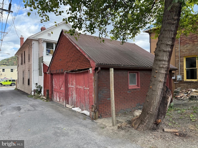 view of side of property featuring brick siding and metal roof