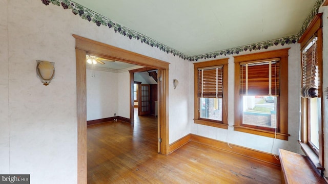 spare room with baseboards and wood finished floors