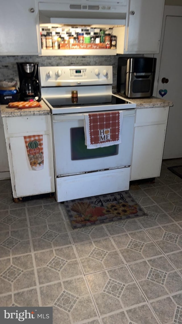 kitchen featuring white cabinetry, white electric stove, and extractor fan