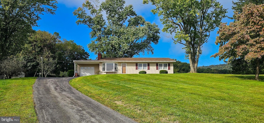 single story home featuring a front lawn and a garage