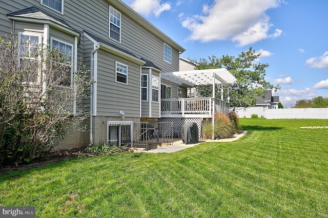 rear view of property with a patio, a deck, and a yard