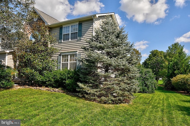 view of side of home featuring a lawn