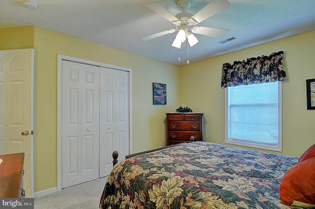 carpeted bedroom featuring a closet, ceiling fan, and a textured ceiling