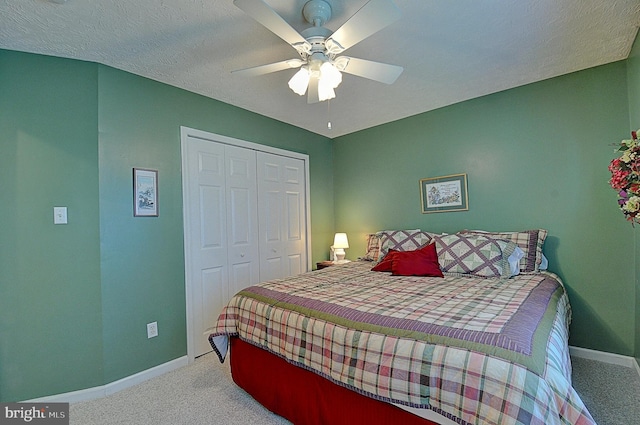 carpeted bedroom with ceiling fan, a textured ceiling, and a closet