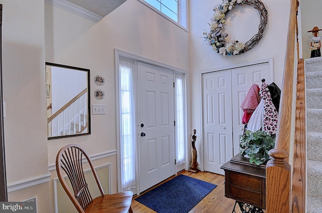 foyer entrance featuring light hardwood / wood-style flooring and ornamental molding