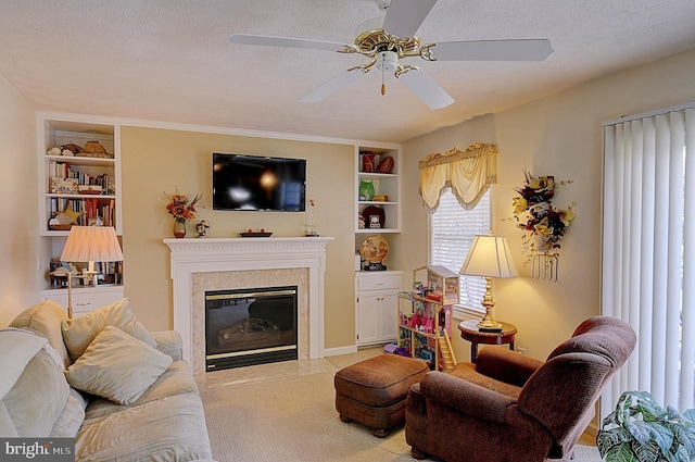 living room featuring a premium fireplace, a textured ceiling, ceiling fan, and built in features