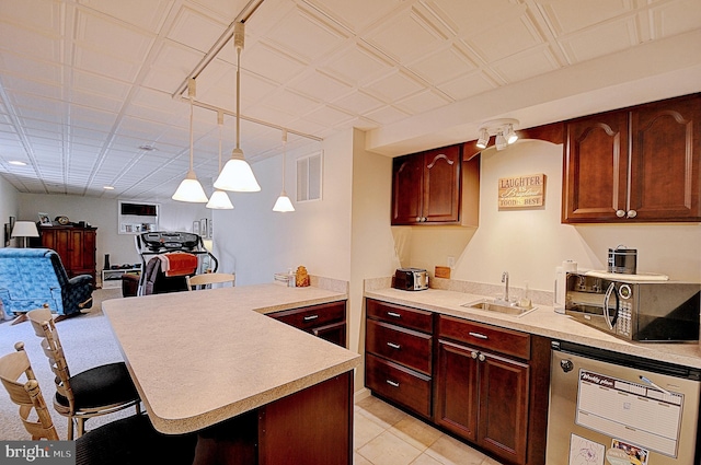 kitchen featuring a breakfast bar, light tile patterned flooring, sink, and decorative light fixtures