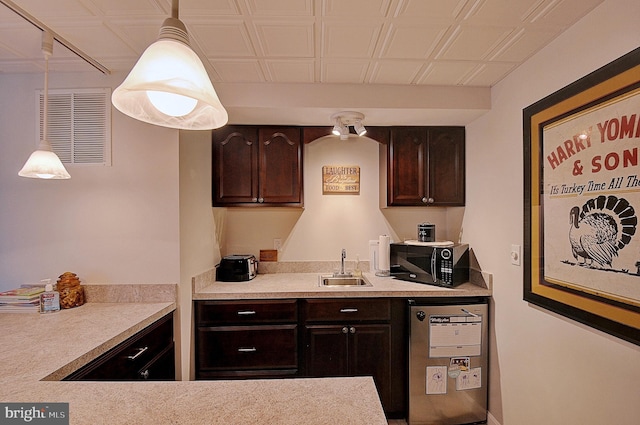 kitchen with dark brown cabinetry, decorative light fixtures, and sink