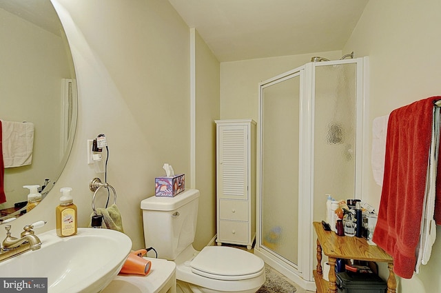 bathroom featuring toilet, sink, and an enclosed shower