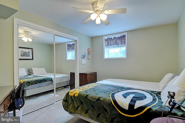 carpeted bedroom featuring ceiling fan and a closet