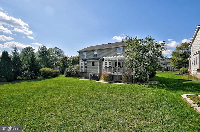 rear view of property with a pergola and a yard