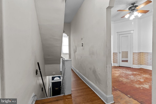 stairway featuring crown molding, hardwood / wood-style flooring, and ceiling fan