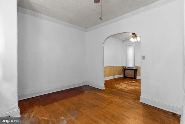 spare room featuring wood-type flooring, ceiling fan, crown molding, and a textured ceiling