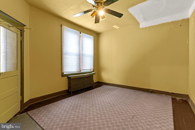 unfurnished bedroom featuring ceiling fan, radiator, and carpet