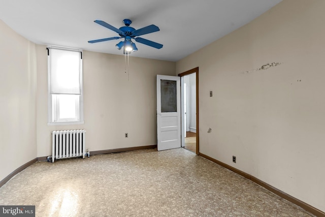 unfurnished room featuring ceiling fan and radiator