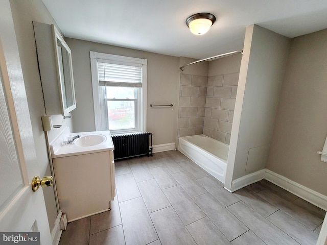 bathroom with tiled shower / bath combo, vanity, and radiator heating unit