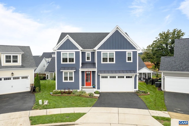 view of front of house featuring a front yard, a garage, and cooling unit