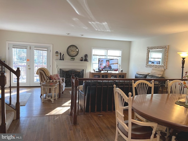 dining space with french doors, a healthy amount of sunlight, and dark wood-type flooring