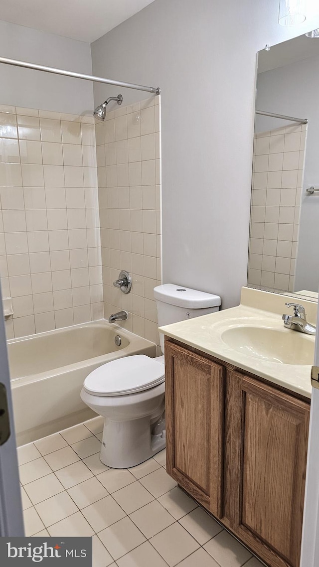 full bathroom featuring vanity, tiled shower / bath combo, toilet, and tile patterned flooring