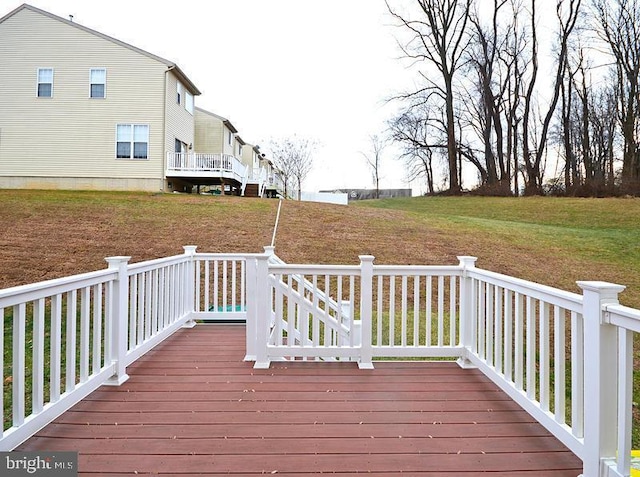 wooden terrace with a lawn