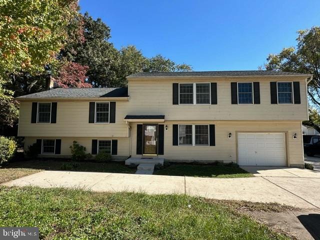 split level home featuring a garage and a front lawn