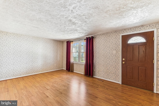 foyer entrance featuring hardwood / wood-style floors and a textured ceiling