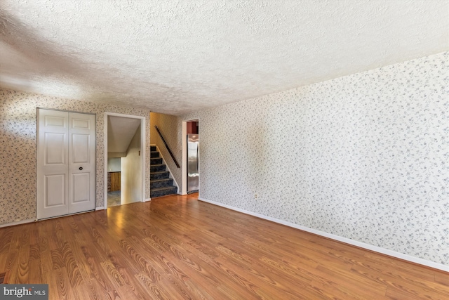 unfurnished room featuring a textured ceiling and hardwood / wood-style flooring