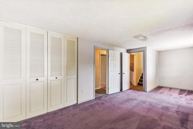 unfurnished bedroom with a closet, carpet flooring, and a textured ceiling