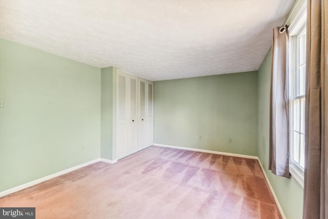 carpeted empty room featuring a textured ceiling