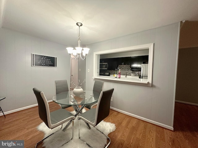 dining area with a notable chandelier and wood-type flooring