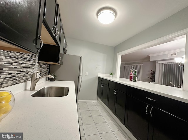 kitchen with decorative backsplash, sink, and light tile patterned floors