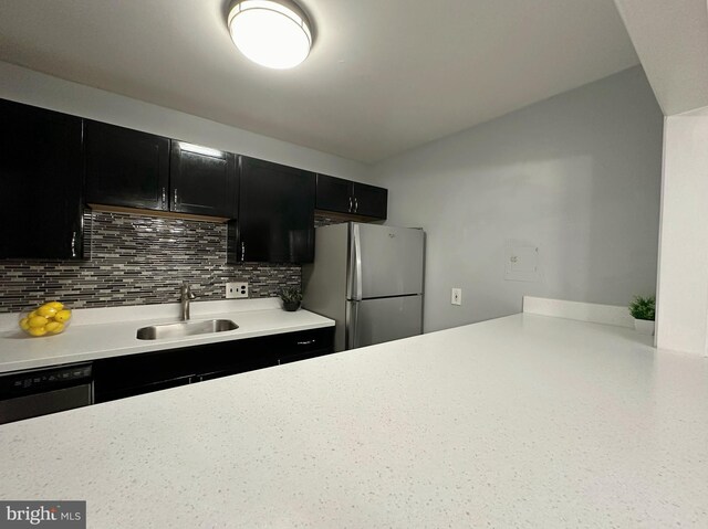 kitchen with black dishwasher, stainless steel refrigerator, sink, and decorative backsplash