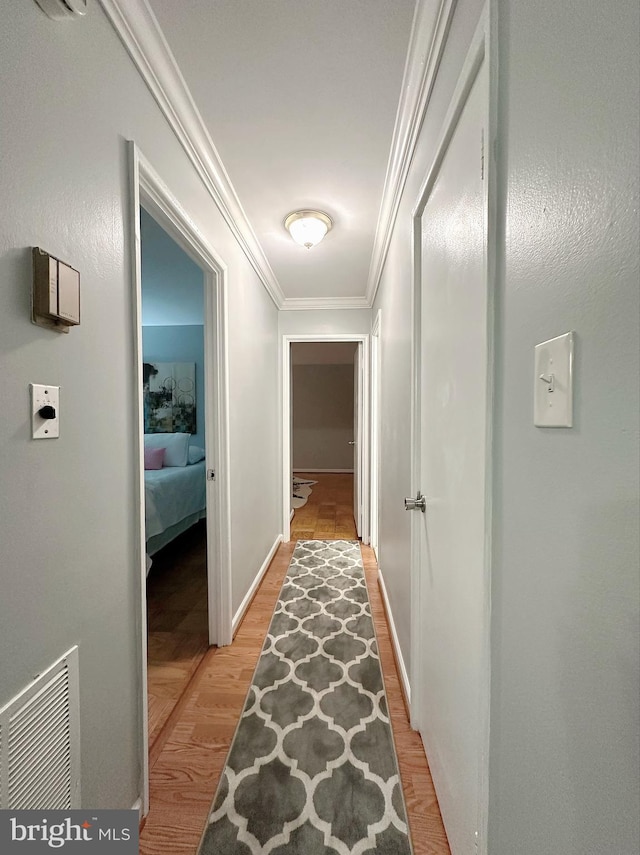 hallway featuring crown molding and light wood-type flooring