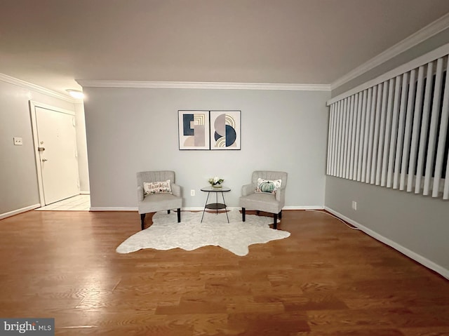 sitting room featuring ornamental molding and hardwood / wood-style flooring