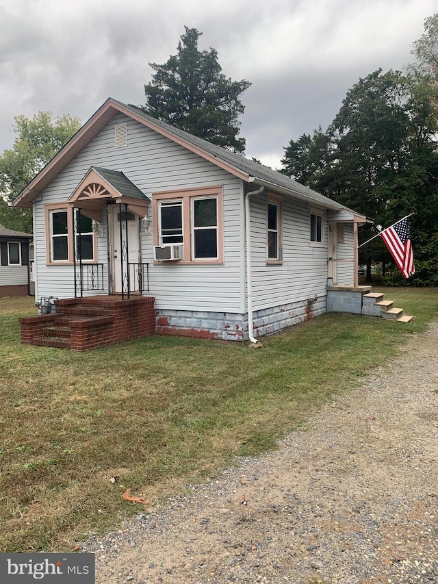 view of front of property featuring cooling unit and a front lawn