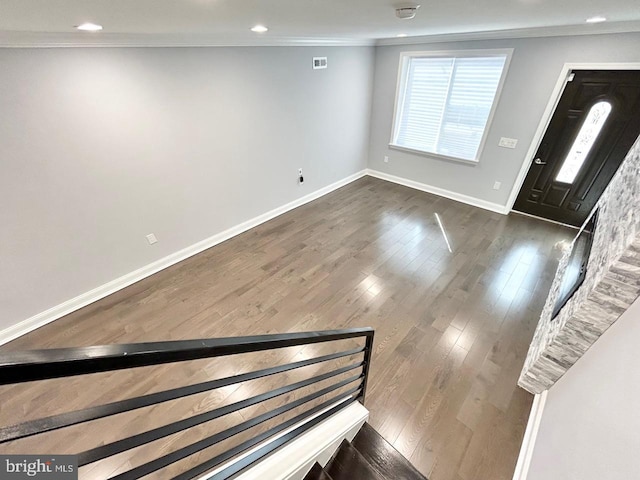 entrance foyer featuring dark wood-type flooring and ornamental molding