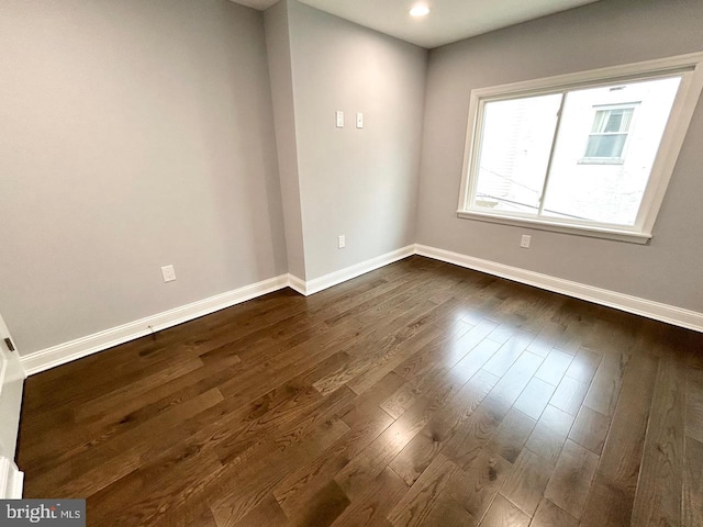 unfurnished room with dark hardwood / wood-style flooring