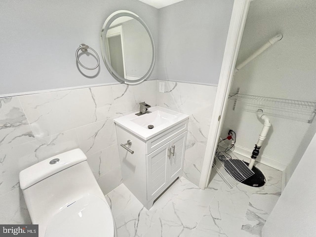 bathroom featuring tile walls, vanity, and toilet