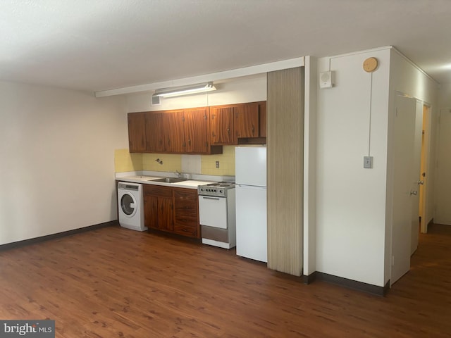 kitchen featuring backsplash, dark hardwood / wood-style flooring, washer / clothes dryer, sink, and white appliances