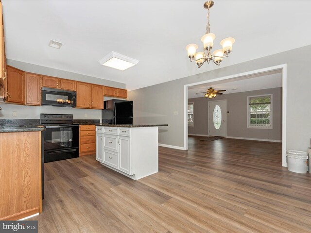 kitchen featuring ceiling fan with notable chandelier, decorative light fixtures, light wood-type flooring, and black appliances