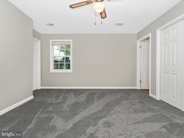 unfurnished bedroom featuring ceiling fan and dark carpet