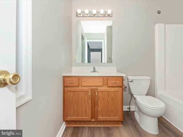 bathroom with hardwood / wood-style flooring, vanity, and toilet