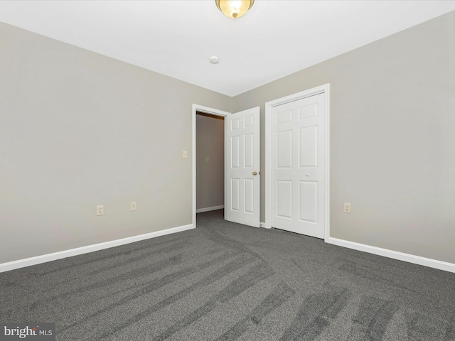 unfurnished bedroom with dark carpet