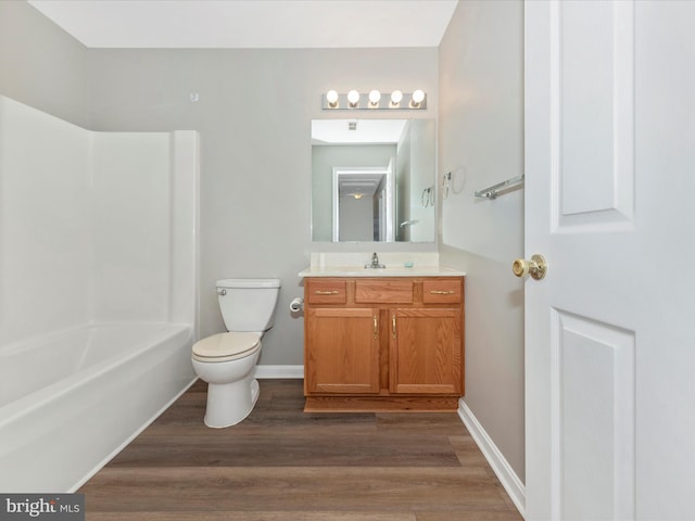 full bathroom with hardwood / wood-style floors, bathtub / shower combination, vanity, and toilet