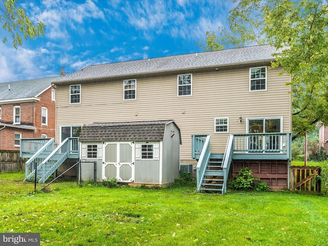 back of property featuring a storage shed, a wooden deck, a lawn, and central AC unit