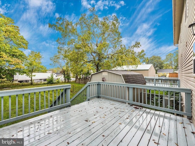 wooden deck with a lawn and a storage unit